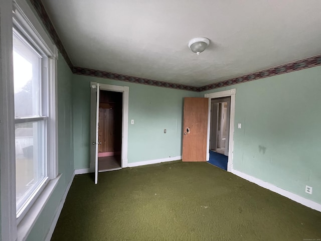 unfurnished bedroom with dark carpet