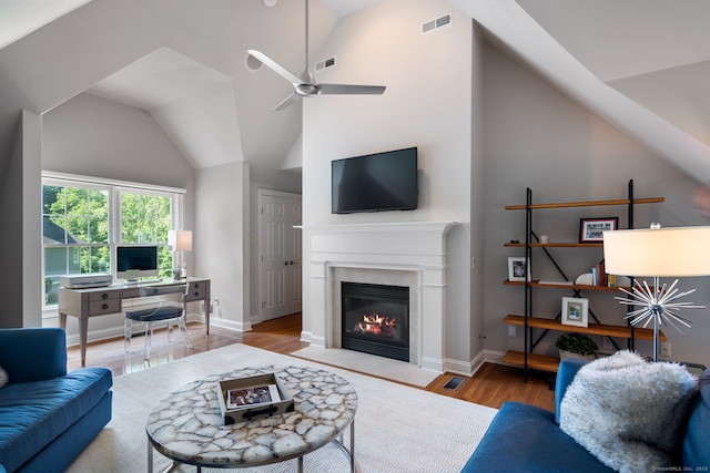 living room with lofted ceiling, ceiling fan, and light wood-type flooring