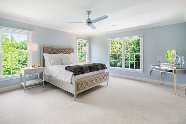 carpeted bedroom featuring crown molding and ceiling fan