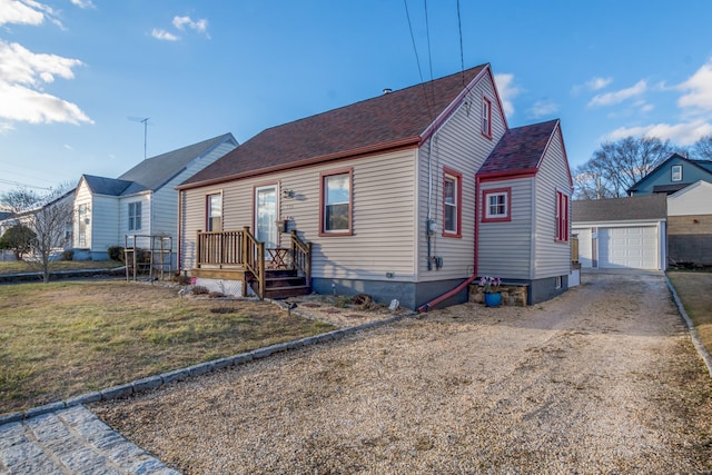 view of front facade featuring an outbuilding, a garage, and a front lawn