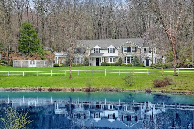 exterior space featuring a front lawn and a water view