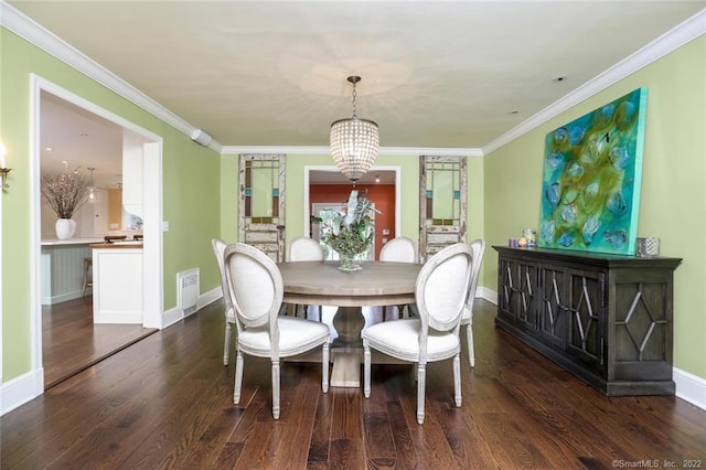 dining area featuring dark hardwood / wood-style flooring, crown molding, and an inviting chandelier