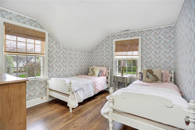 bedroom with vaulted ceiling, dark wood-type flooring, and multiple windows