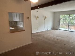 carpeted empty room with beamed ceiling, ceiling fan, and baseboards