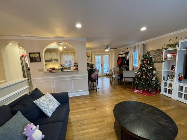 living room with french doors, ornamental molding, sink, and light hardwood / wood-style flooring