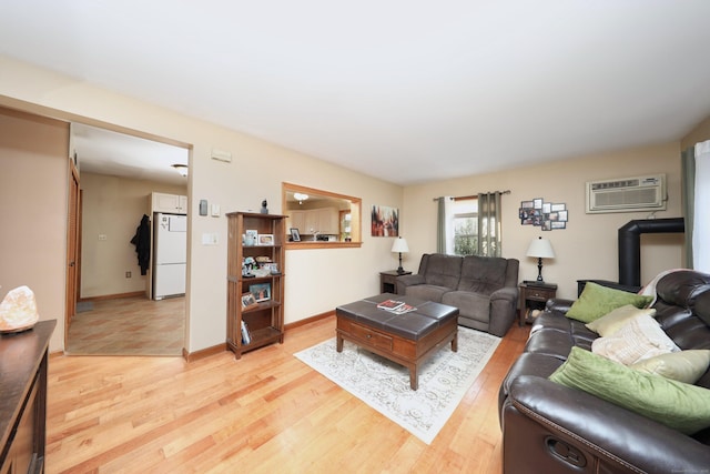 living room with a wall mounted AC and light wood-type flooring