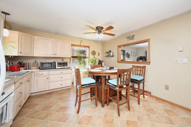 kitchen with white oven, decorative backsplash, ceiling fan, and pendant lighting