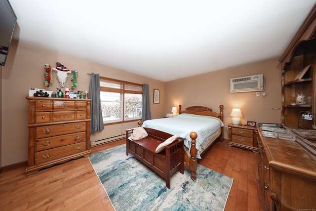 bedroom with light hardwood / wood-style floors, baseboard heating, and a wall unit AC