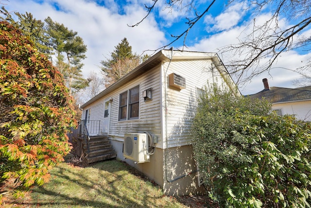 view of home's exterior with ac unit and a yard