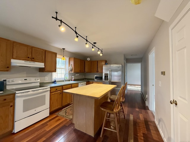 kitchen with sink, a center island, a kitchen breakfast bar, decorative light fixtures, and appliances with stainless steel finishes