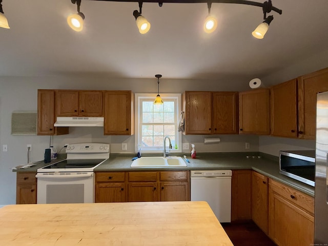 kitchen featuring sink, stainless steel appliances, decorative light fixtures, and wood counters