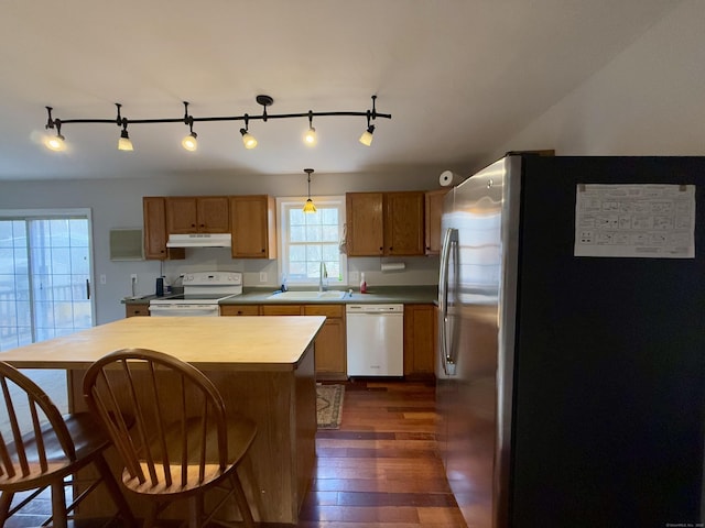 kitchen with pendant lighting, white appliances, dark wood-type flooring, and sink