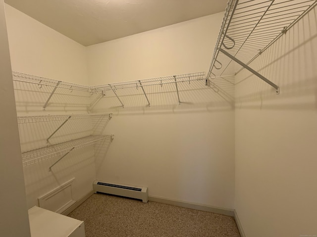 walk in closet featuring carpet floors and a baseboard heating unit