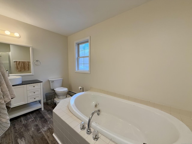 bathroom featuring vanity, hardwood / wood-style flooring, a relaxing tiled tub, toilet, and a baseboard radiator