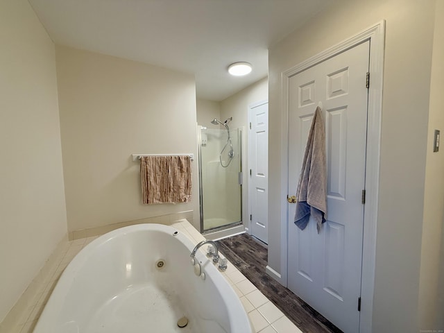 bathroom with hardwood / wood-style floors and shower with separate bathtub