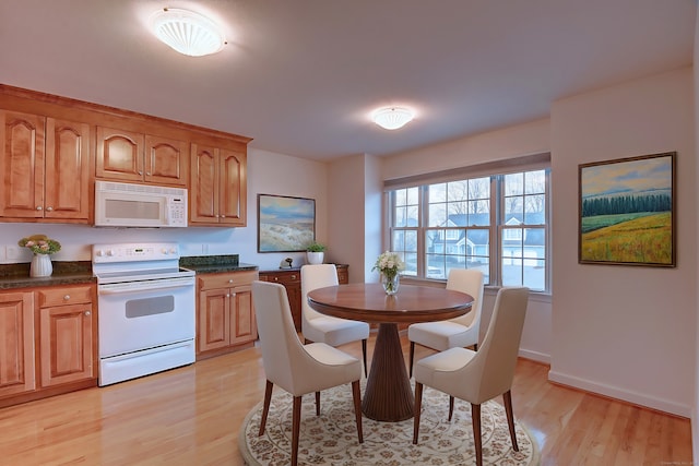 kitchen featuring light wood-type flooring and white appliances