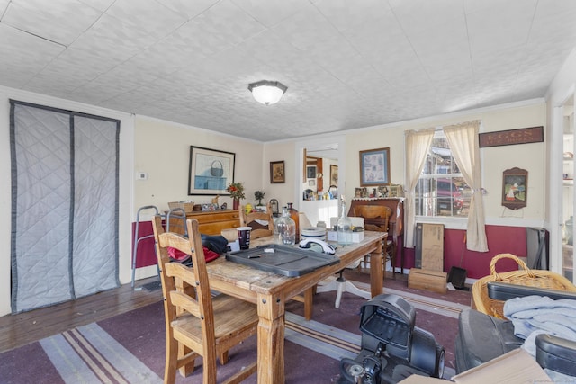 dining space with hardwood / wood-style flooring and ornamental molding