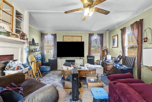 living room featuring ceiling fan, a fireplace, and a wealth of natural light