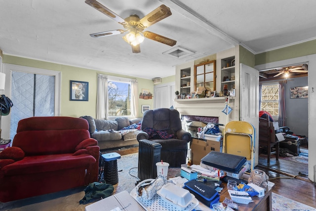 living room featuring hardwood / wood-style flooring, built in features, and ceiling fan