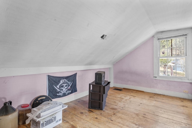 additional living space featuring wood-type flooring and lofted ceiling