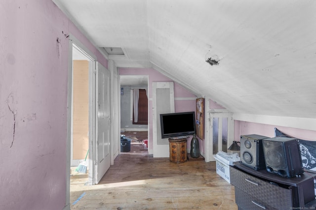 bonus room with lofted ceiling and light wood-type flooring