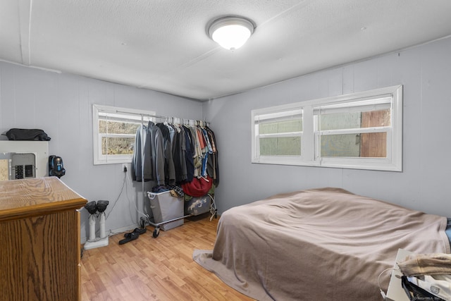 bedroom featuring a textured ceiling and light hardwood / wood-style flooring