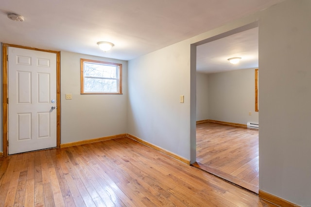 empty room with a baseboard heating unit and light wood-type flooring