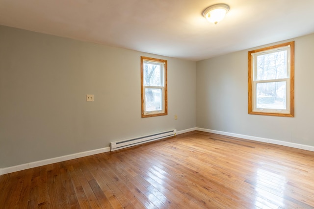 unfurnished room with light wood-type flooring and a baseboard radiator