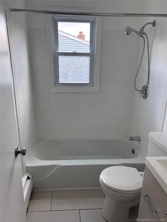 full bathroom featuring tiled shower / bath combo, baseboard heating, tile patterned flooring, toilet, and vanity