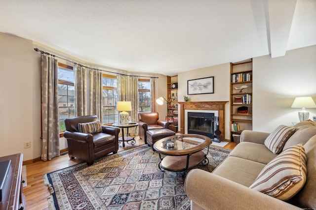 living room featuring beam ceiling and light hardwood / wood-style flooring