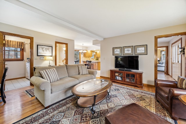 living room with light hardwood / wood-style flooring and an inviting chandelier