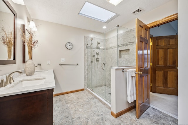 bathroom with vanity, a skylight, and an enclosed shower