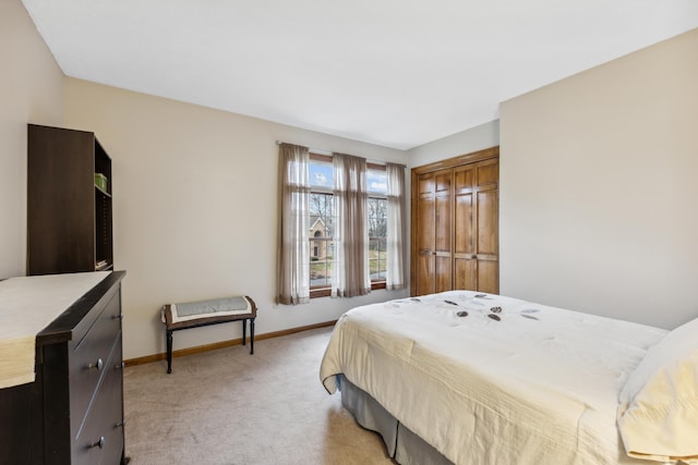 bedroom featuring light colored carpet and a closet