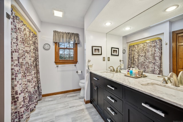 bathroom with vanity, toilet, and curtained shower