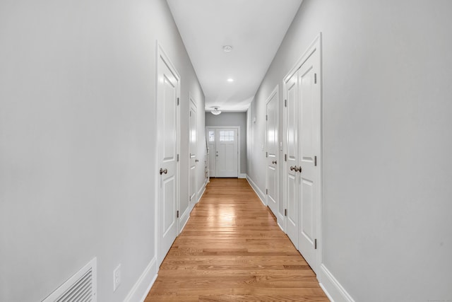 hallway with light hardwood / wood-style floors