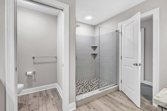 bathroom featuring a tile shower and toilet