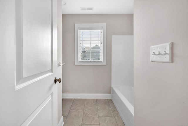 interior space with tile patterned floors and a bathing tub