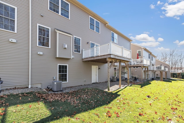 rear view of property featuring a lawn, a deck, and central air condition unit