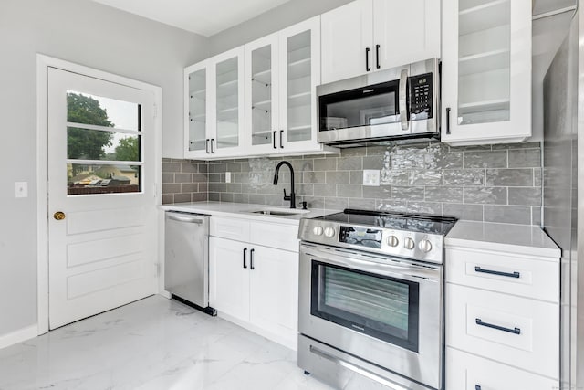 kitchen with backsplash, white cabinetry, sink, and appliances with stainless steel finishes