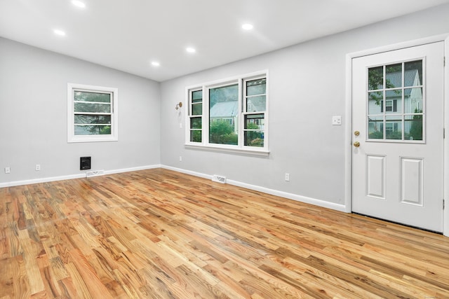 unfurnished room with light wood-type flooring, plenty of natural light, and lofted ceiling