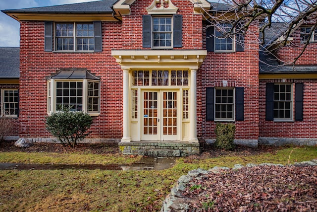 exterior space with french doors and brick siding