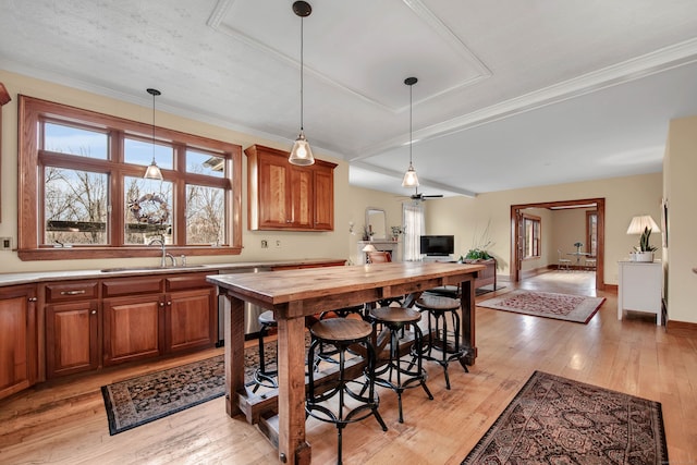 kitchen with brown cabinets, dishwasher, open floor plan, and a sink