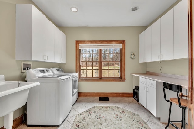 washroom featuring cabinets, washer and clothes dryer, and sink