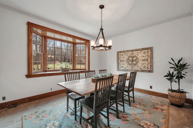 carpeted dining space featuring ornamental molding, baseboards, and a notable chandelier