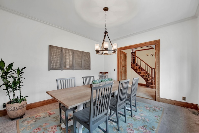 carpeted dining area with baseboards, an inviting chandelier, stairs, and crown molding