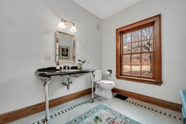 bathroom featuring tile patterned flooring, toilet, and sink