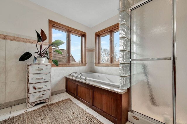 bathroom featuring tile patterned flooring, tile walls, and plus walk in shower