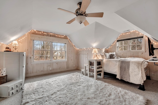 bedroom with lofted ceiling, baseboards, wood walls, and carpet floors
