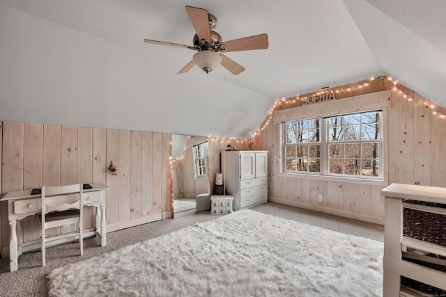 additional living space featuring vaulted ceiling, wood walls, a ceiling fan, and carpet