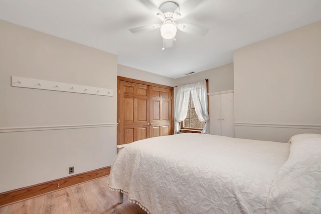 bedroom with ceiling fan, a closet, and light hardwood / wood-style flooring